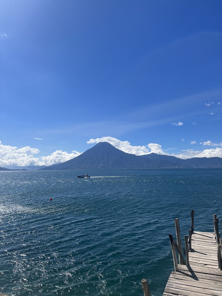 photo showing lake Atitlan with volcano in the background and pier on the right side