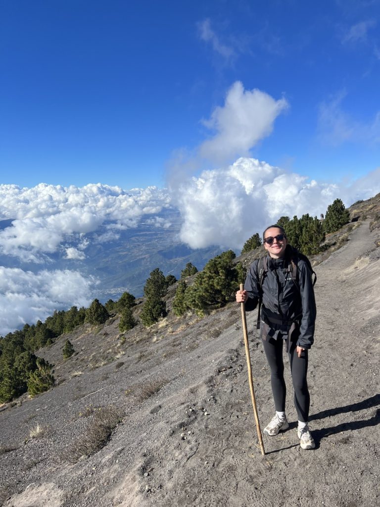 A photo of me on the last stretch of the volcano Acatenango hike, with views down the side over Guatemala