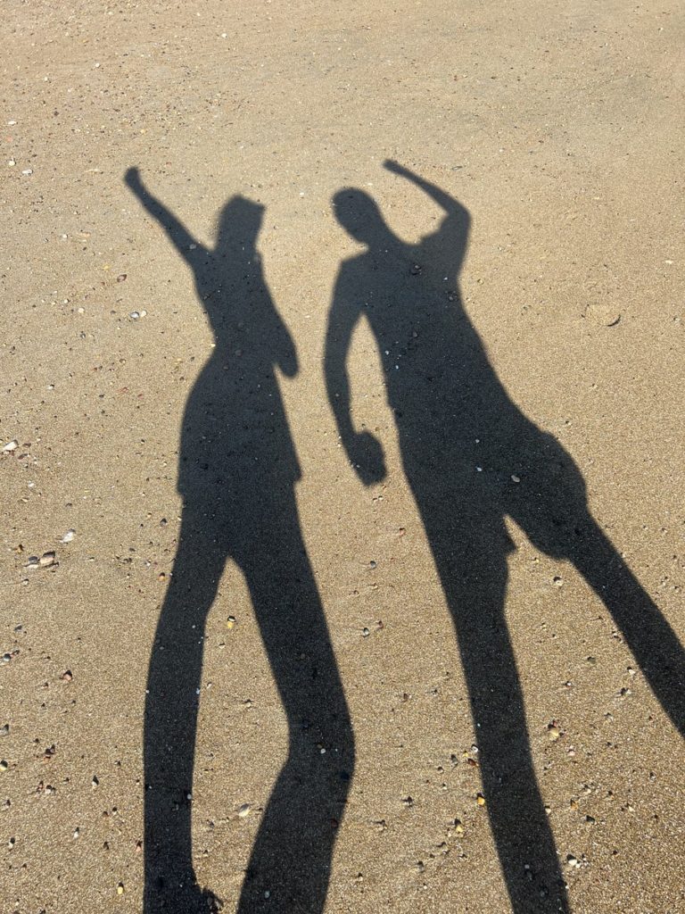 photo of mine and joshs shadows in the sand in montezuma, costa rica