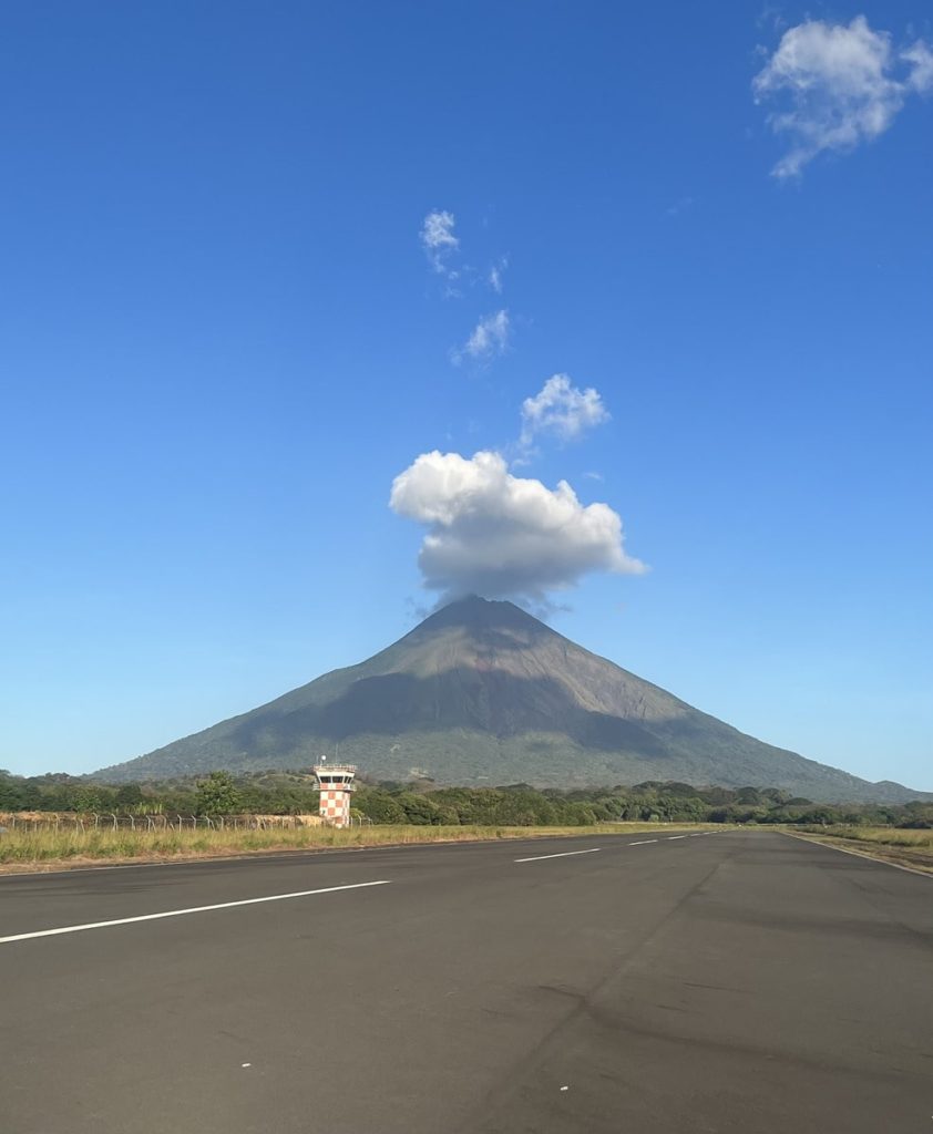 photo of Volcano Concepcion from the airport runway with a slight cloud above.