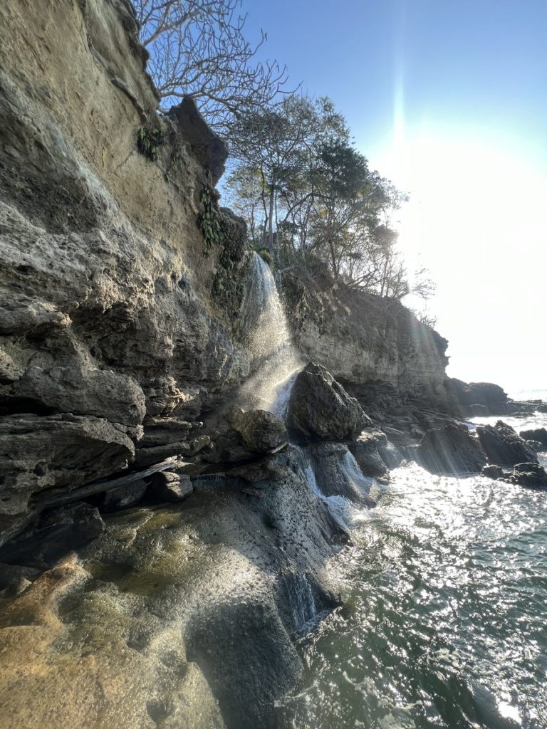 photo of a small waterfall falling in to tide pools in the sea