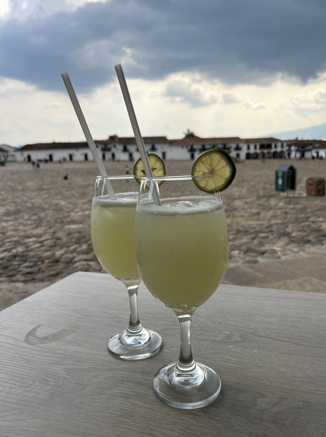 photo of two lemonades with plaza mayor in villa de leyva in the background