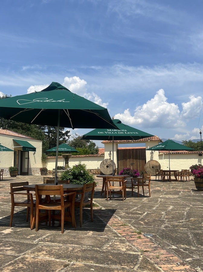 photo of the seating area at vineyard with umbrellas, tables and chairs on stone flooring