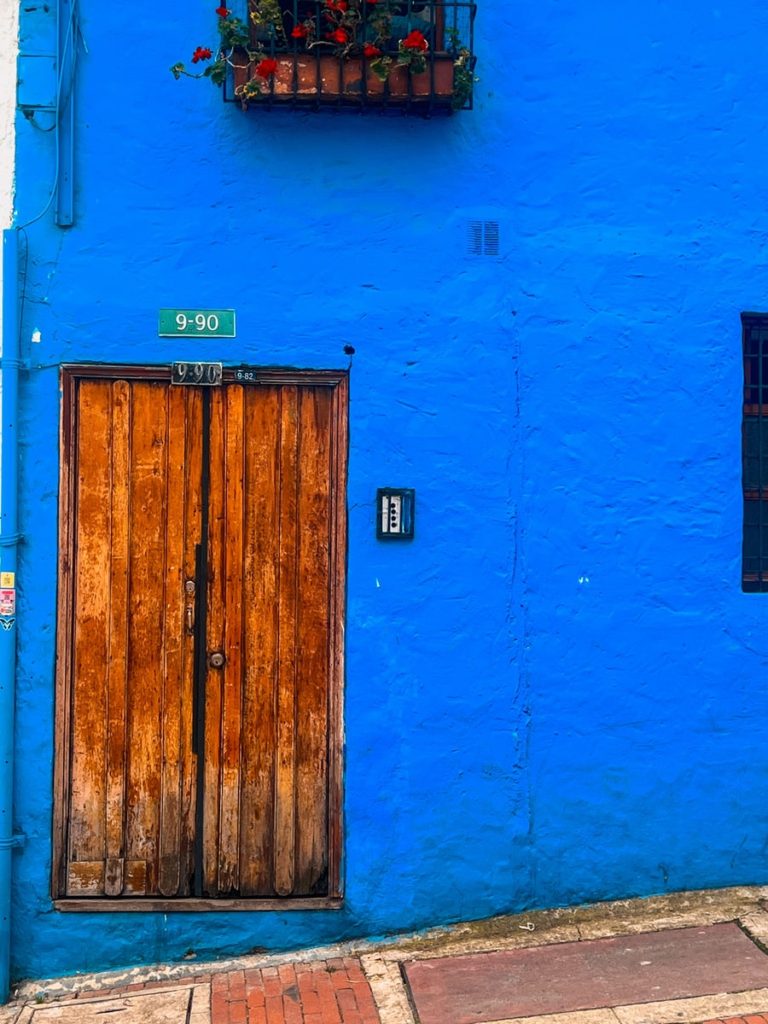 photo of blue building with old wooden door in la candelaria bogota