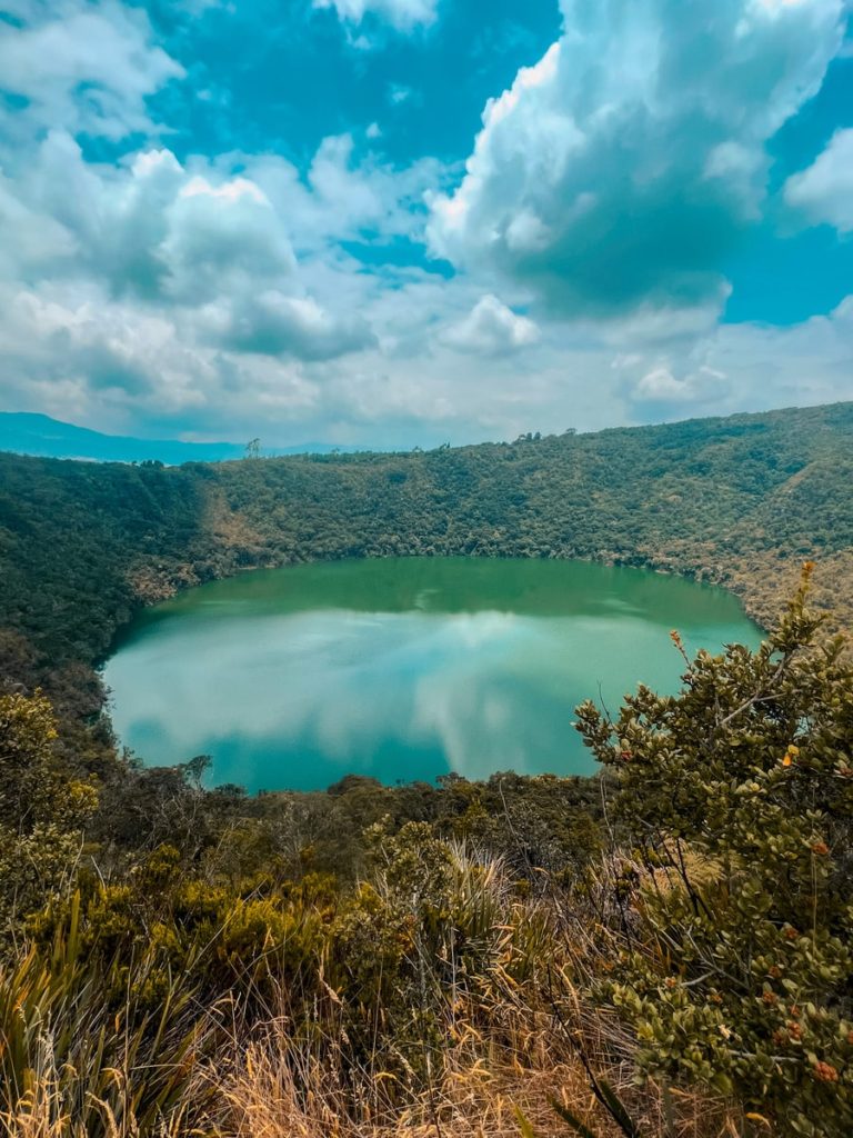 photo overlooking lake guatavita surrounded by dense forest
