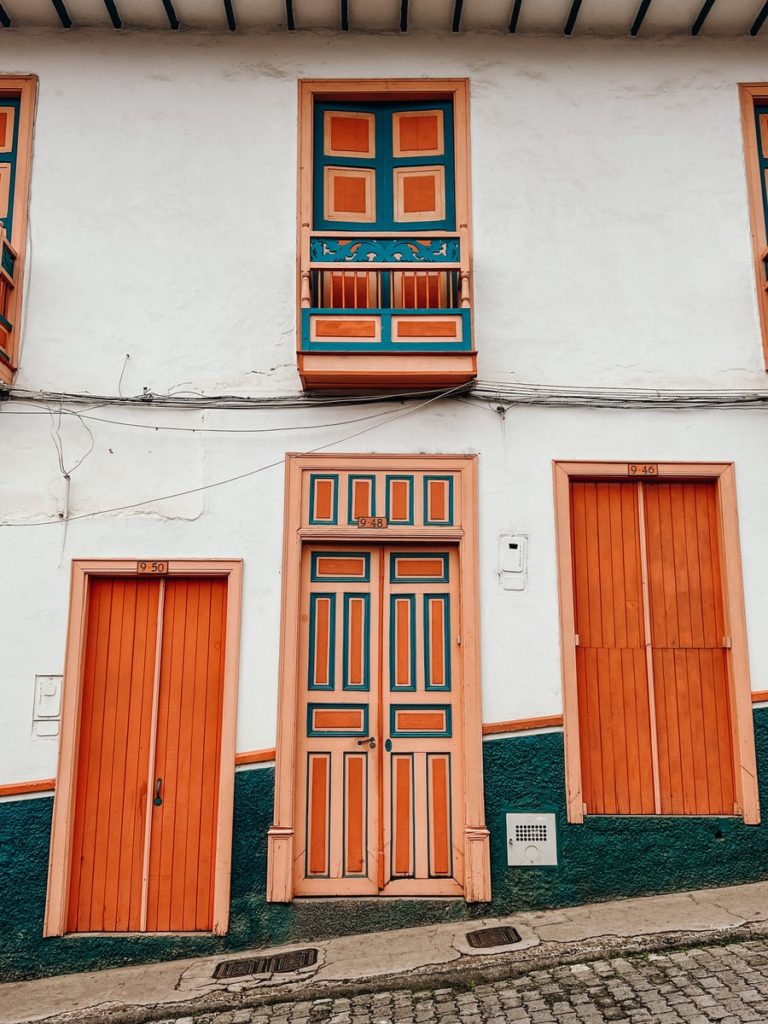 photo of building with orange doors with blue lining in jerico, colombia