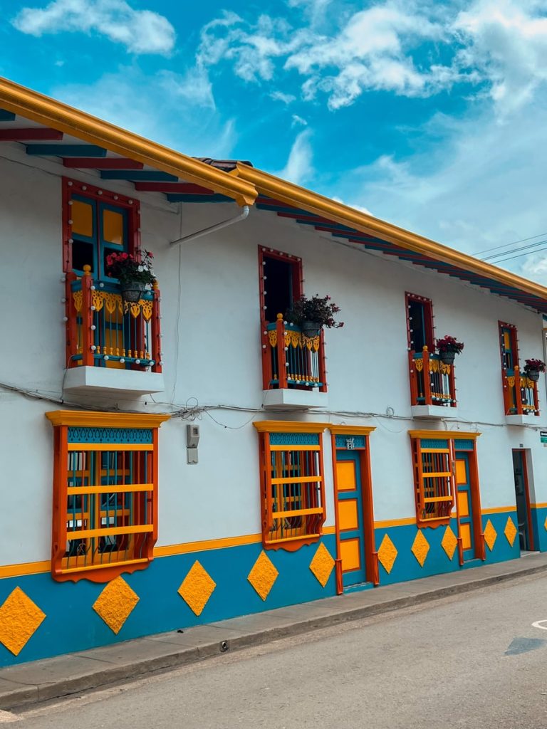 photo of white building with bright blue, yellow, red and green trims in jardin colombia