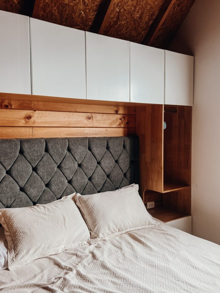 photo of bed and cabinets above in a cabin