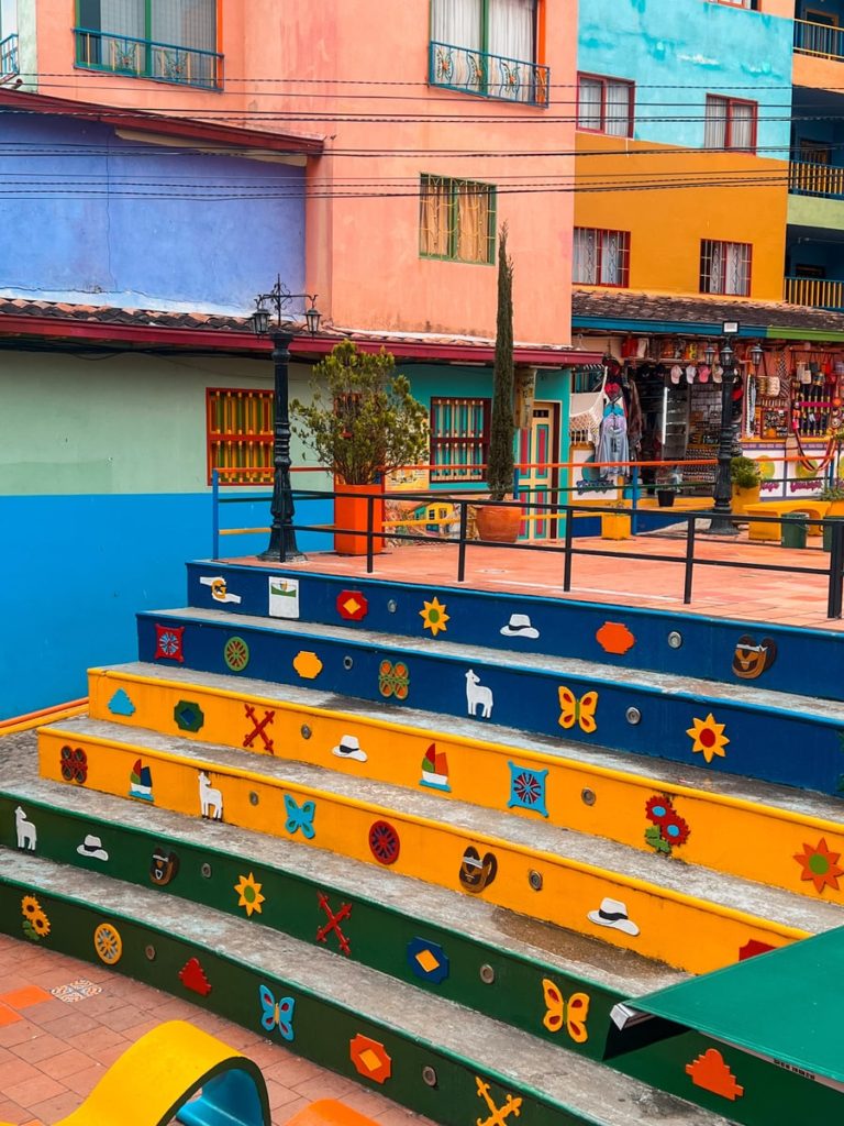 photo of blue, yellow and green steps with images in plaza zocalo in guatape colmbia