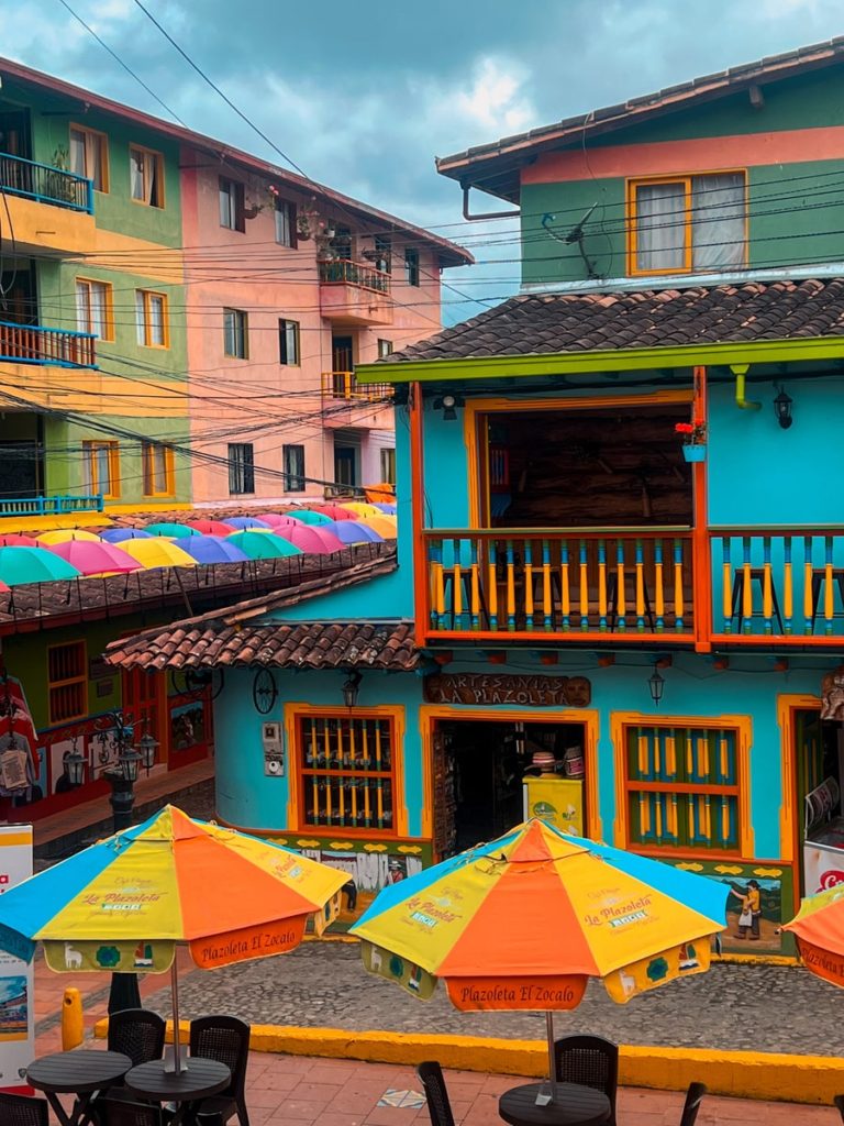 photo looking at plaza de zocalos from vina cafe in guatape colombia, bright coloured buildings