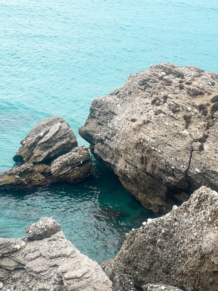 photo of blue sea waters in nerja with rock formations