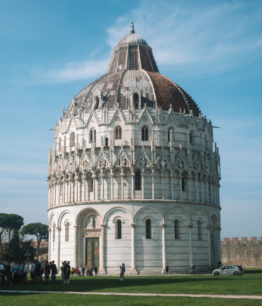 photo of baptistery with a crowd of people in the square of miracles in pisa