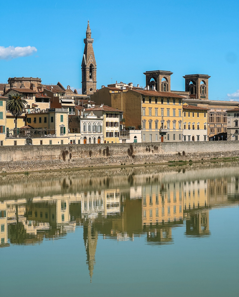 photo of florence riverside with strong reflection in the arno river of the buildings
